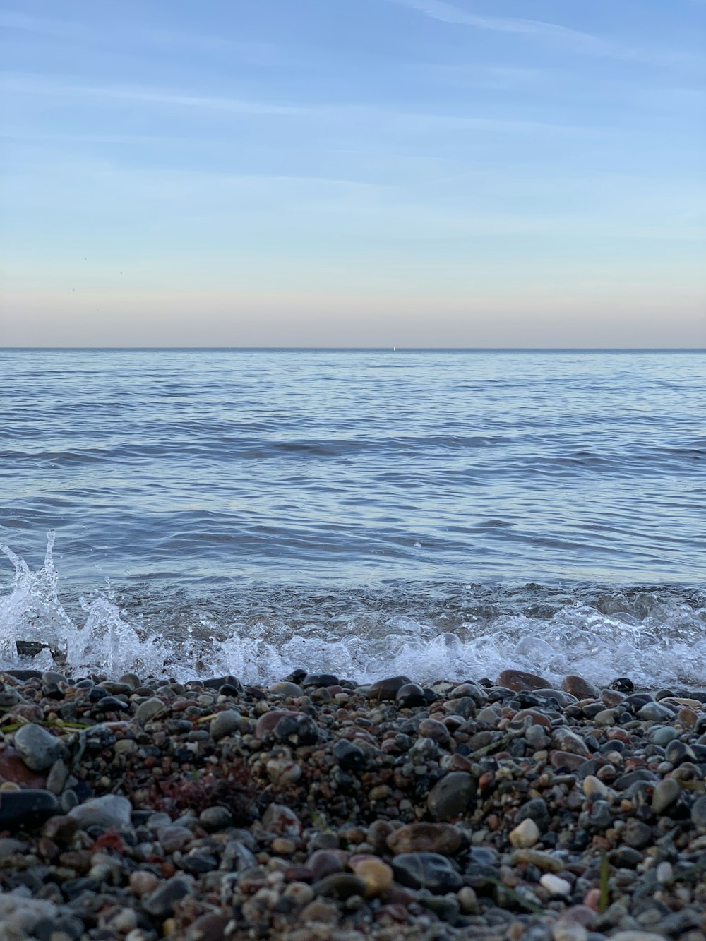 a wave rolls in on a rocky beach