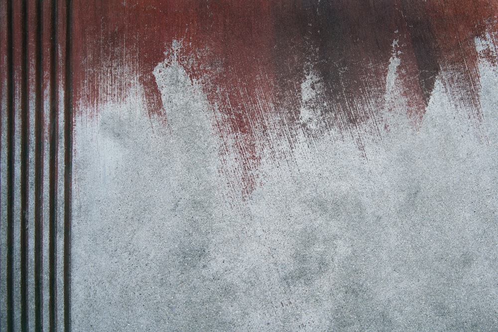 a grungy red and white wall with vertical lines