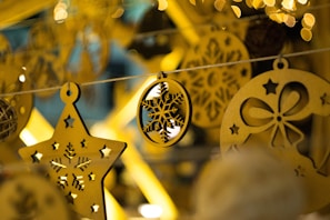 Wooden Christmas decorations with intricate cut-out patterns displayed on a rustic table.