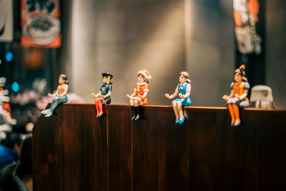 women action figures sits on brown wooden panel