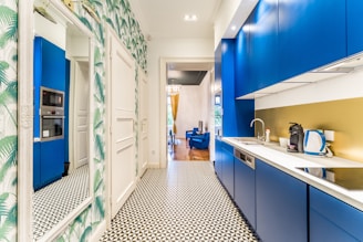 a kitchen with blue cabinets and a tiled floor