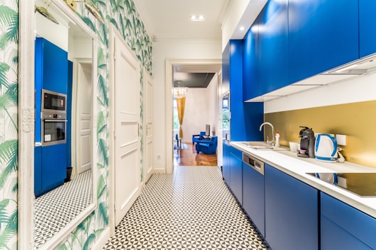 a kitchen with blue cabinets and a tiled floor