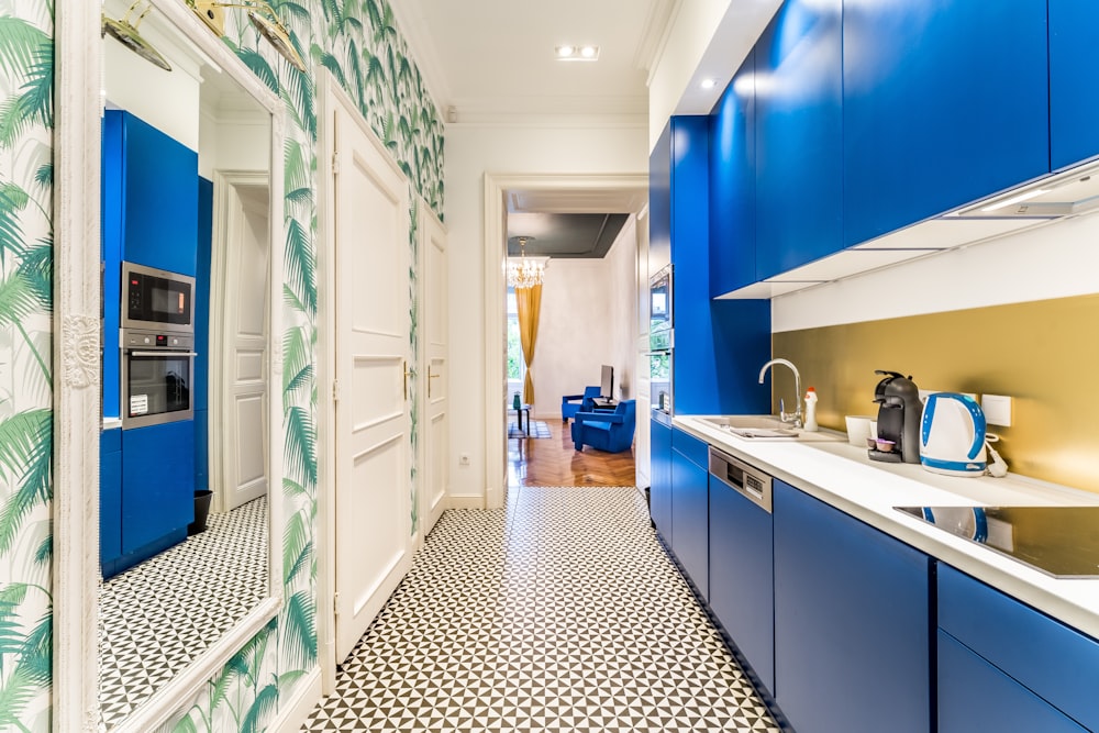 a kitchen with blue cabinets and a tiled floor