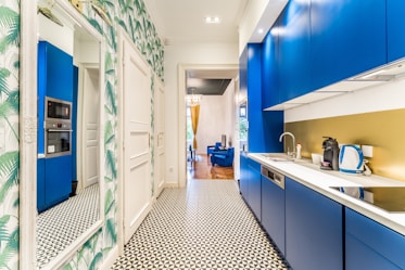 a kitchen with blue cabinets and a tiled floor