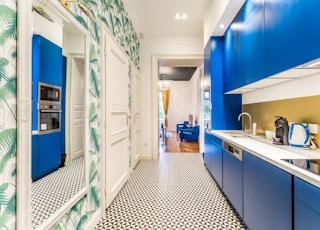 a kitchen with blue cabinets and a tiled floor