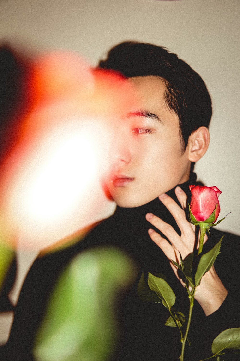 man holding red rose flower