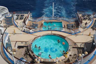 Family having fun by the pool on a cruise ship with ocean views.