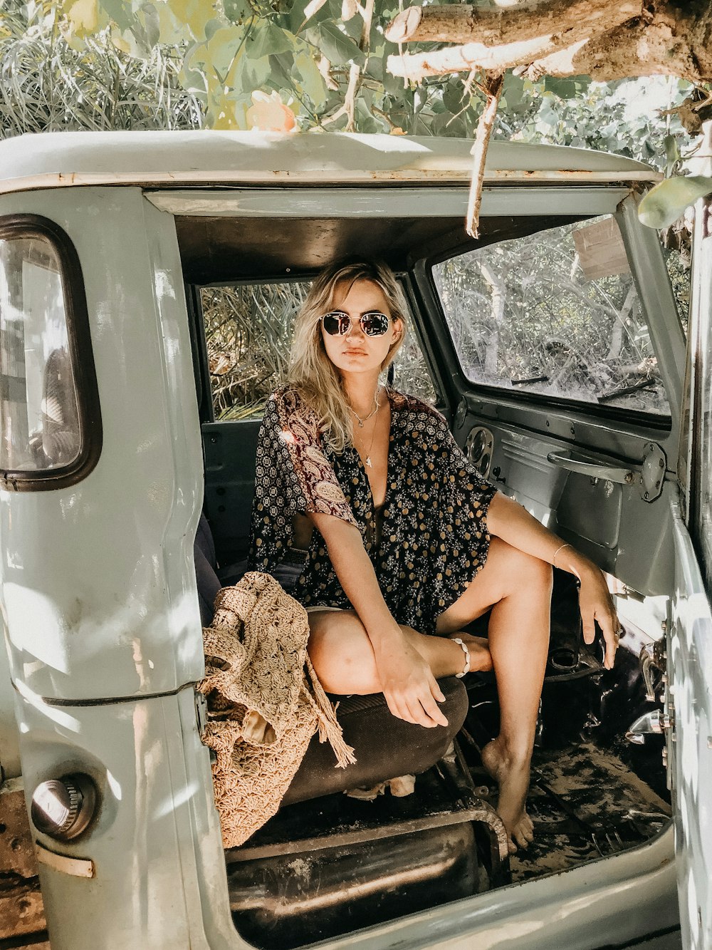 woman in black and brown blouse sitting inside classic vehicle during daytime