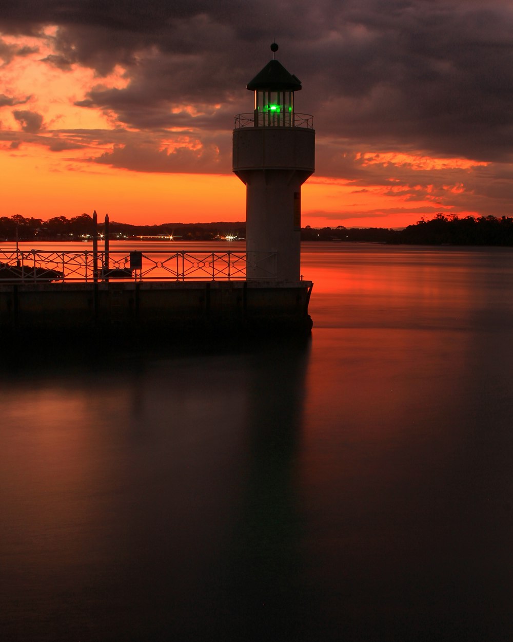 red and black sky and a lighthouse