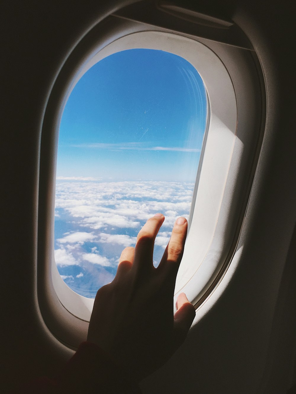 left human hand near plane window