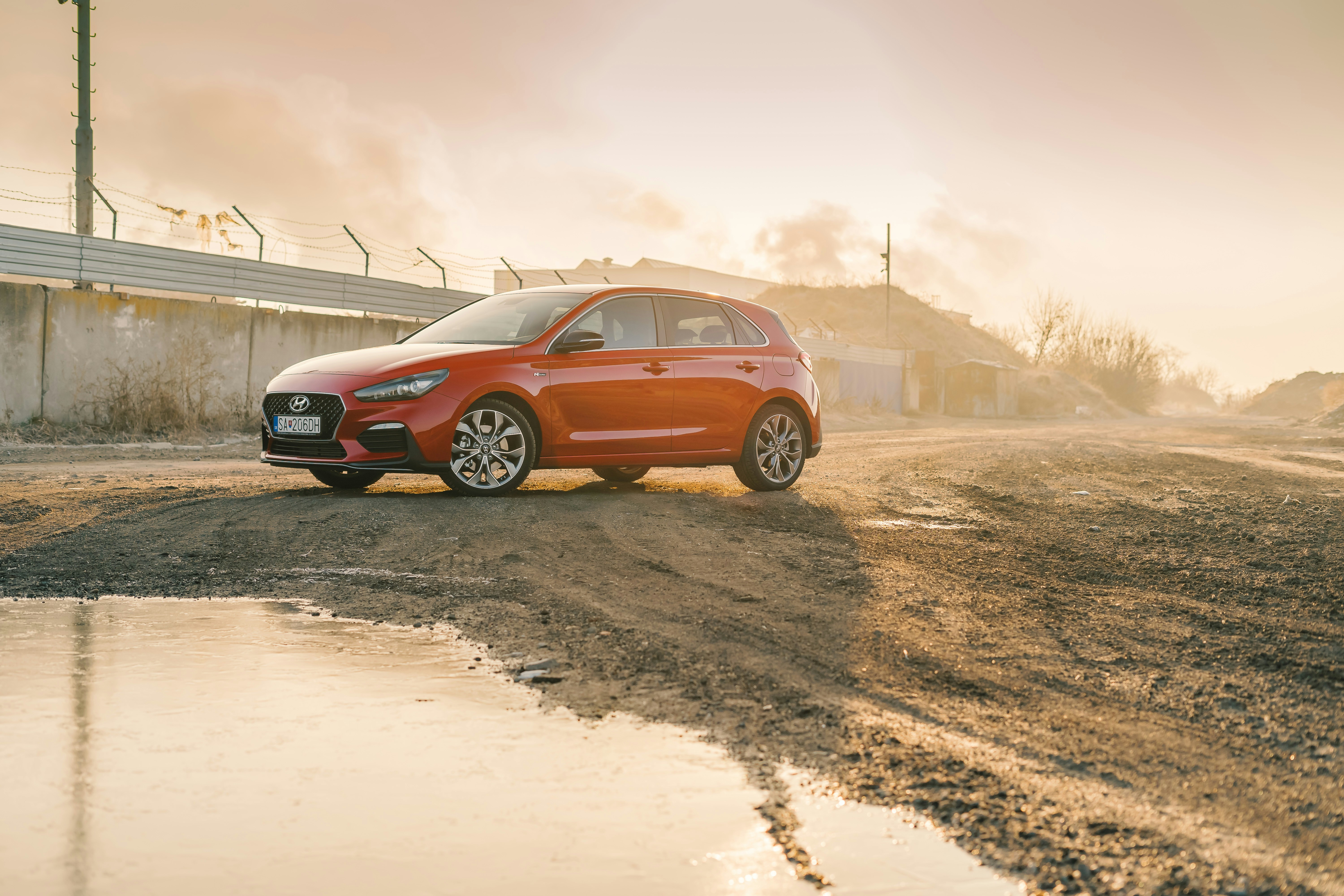 orange SUV parks on dirt road