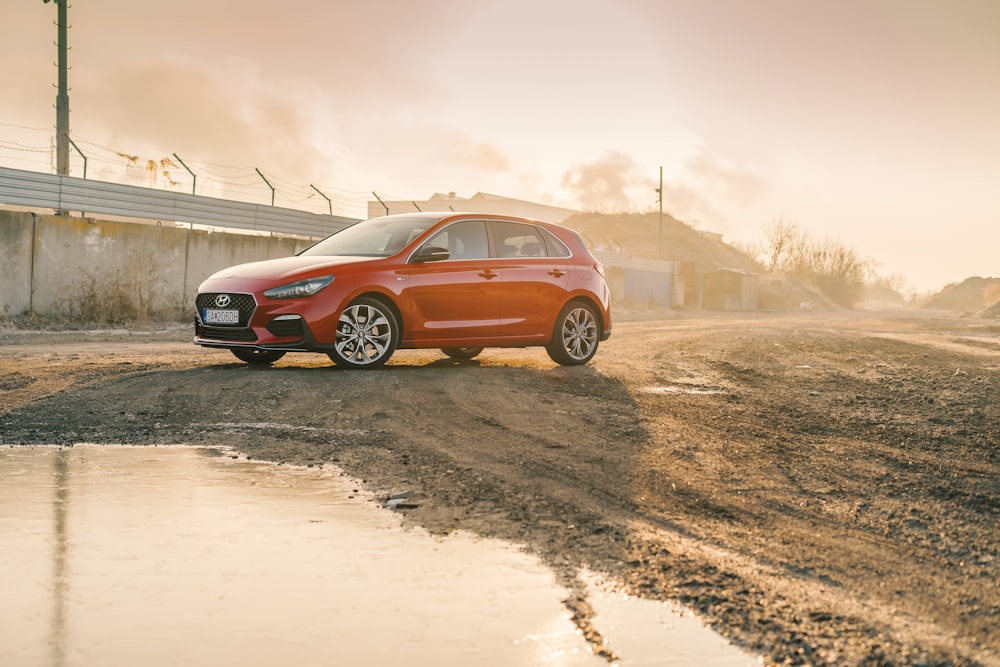 orange SUV parks on dirt road