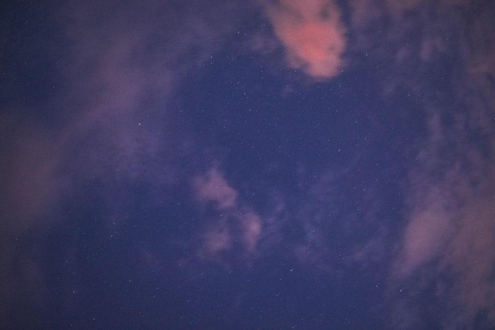 a night sky with a few clouds and stars