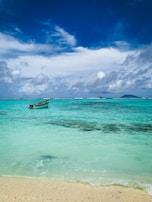 Tourists enjoying a peaceful boat ride around the nearby islands, framed by turquoise waters and blue skies.