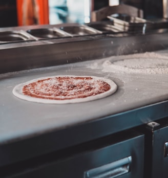 a pizza being made on a pizza stone