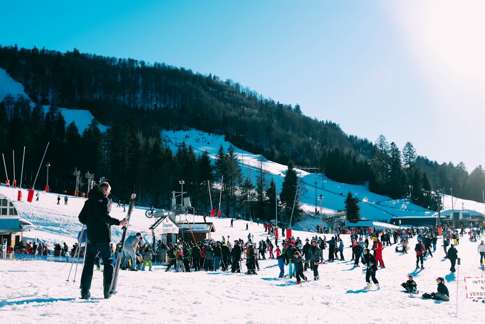 people stands on ski slope during day time