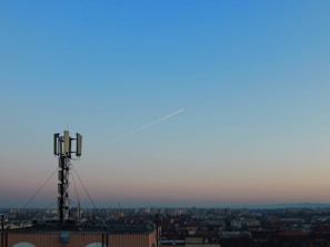 City skyline at dusk with glowing telecom towers and network signals.