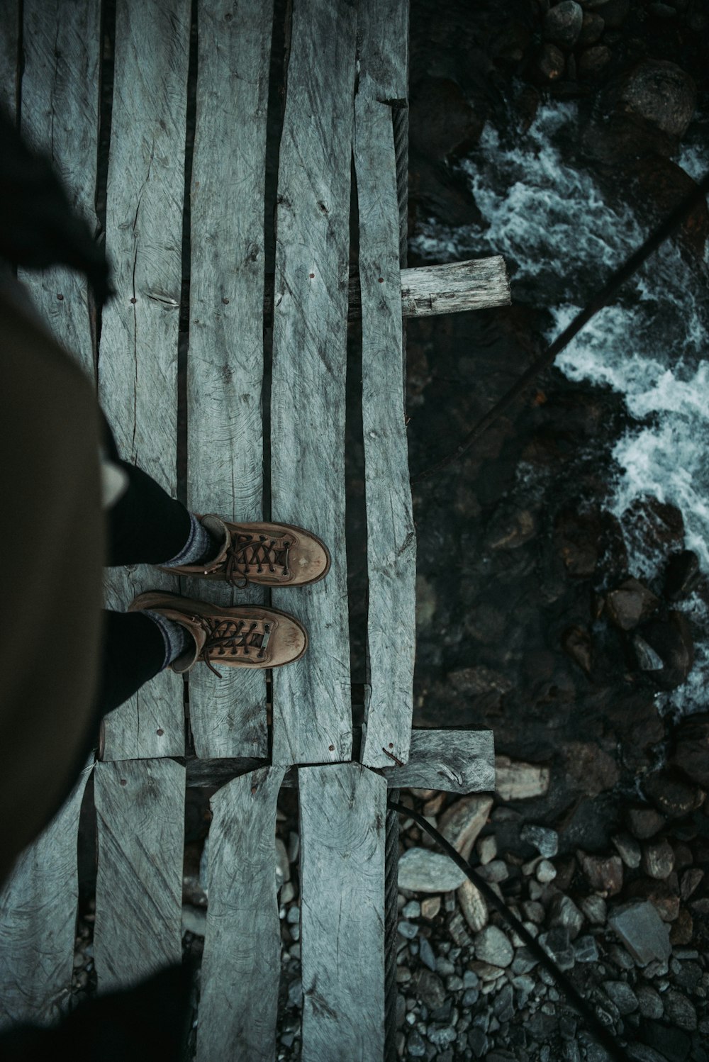 person standing on gray wooden surface