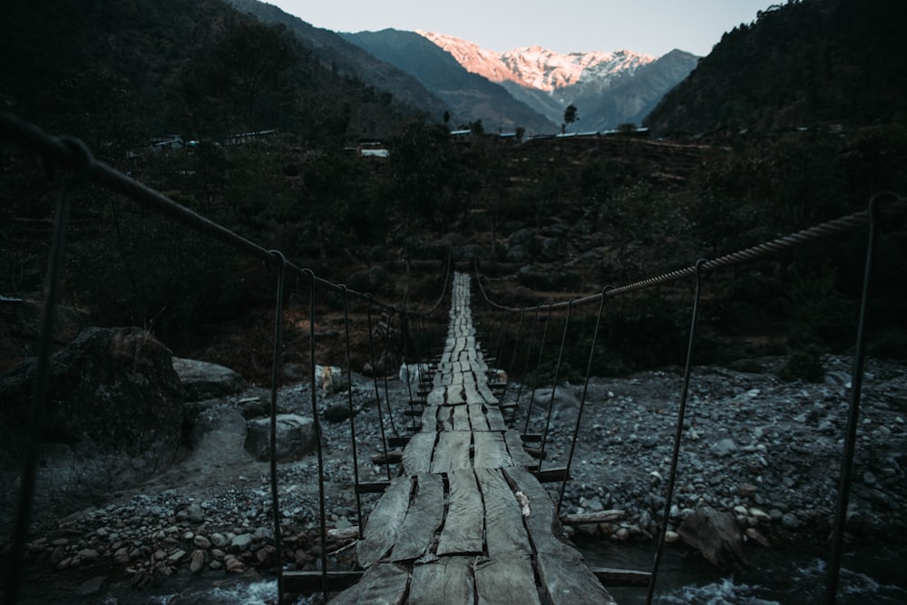 wooden floor hanging bridge above rocky river