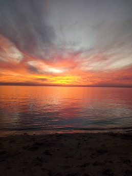 A breathtaking sunset over a tranquil beach, capturing the essence of a perfect vacation moment.