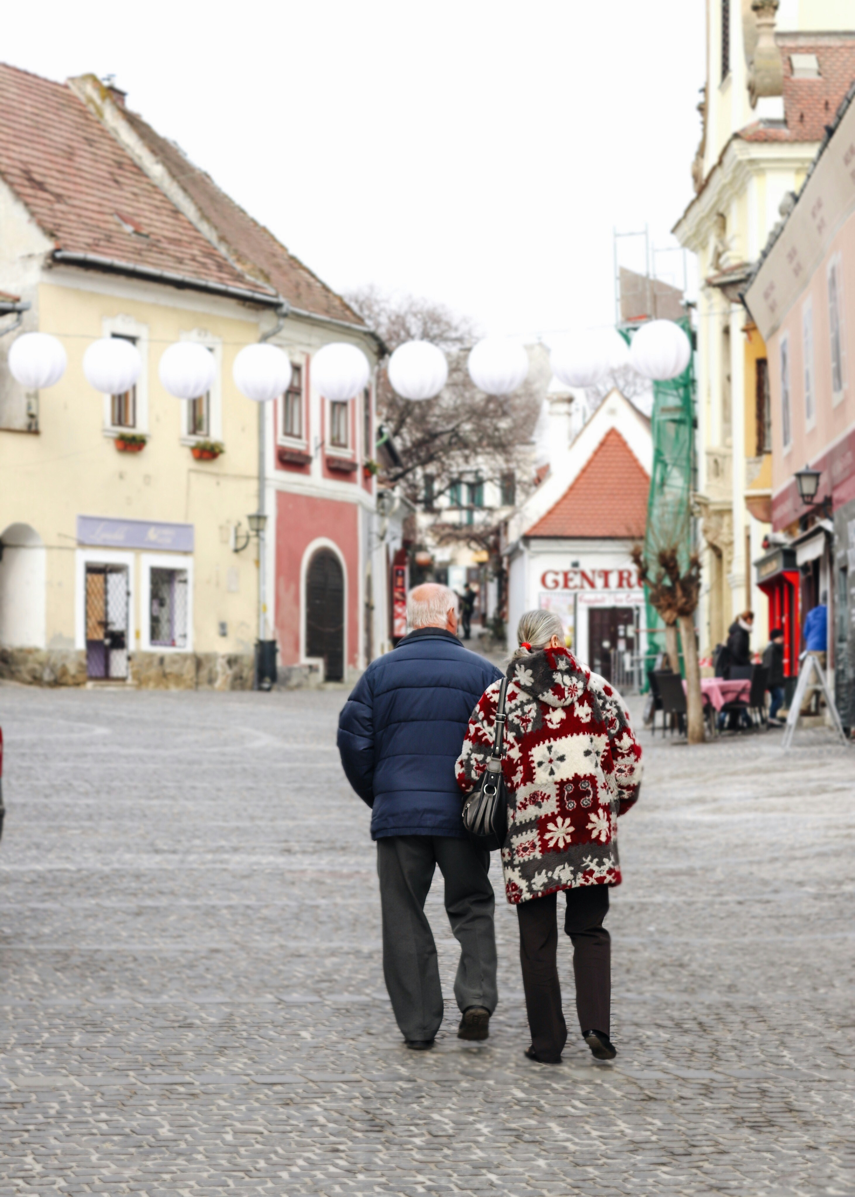 old couple standing on concrete pavement near building