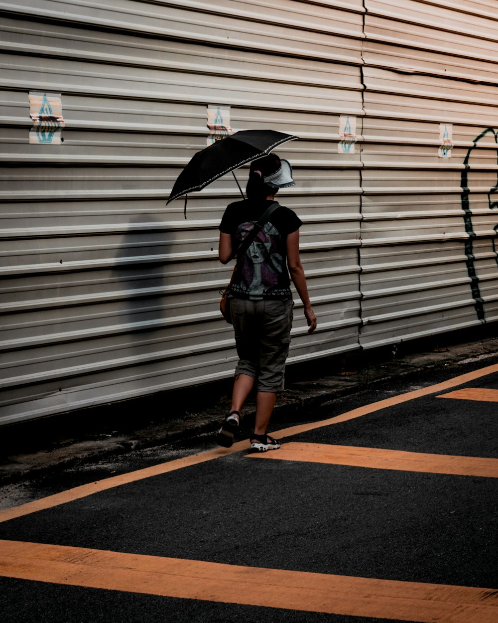 woman walking beside galvanized iron sheets