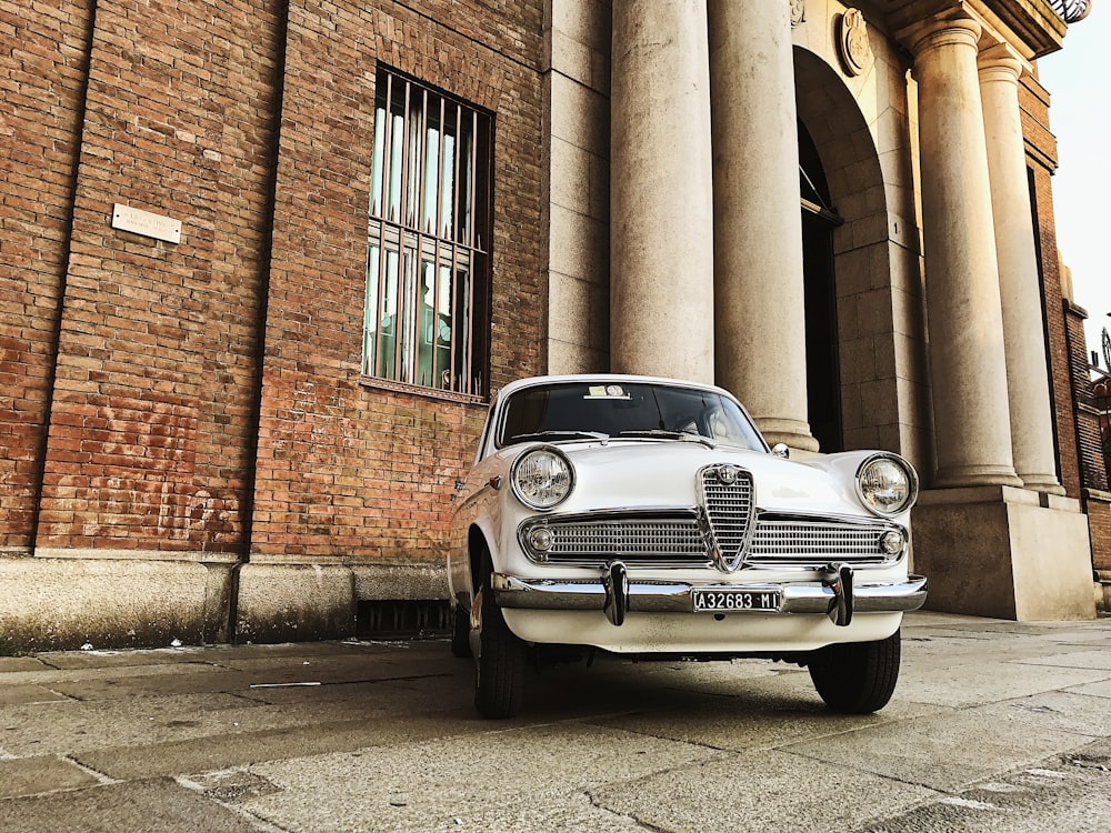 white Alpha Romeo car parked near building