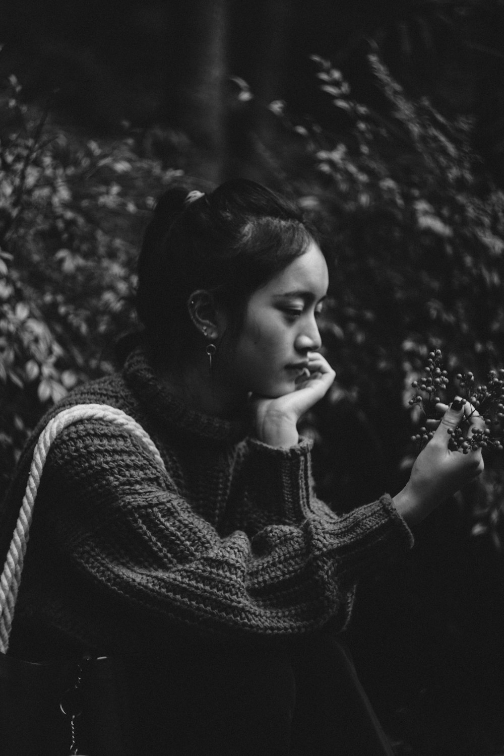 woman looking at flower