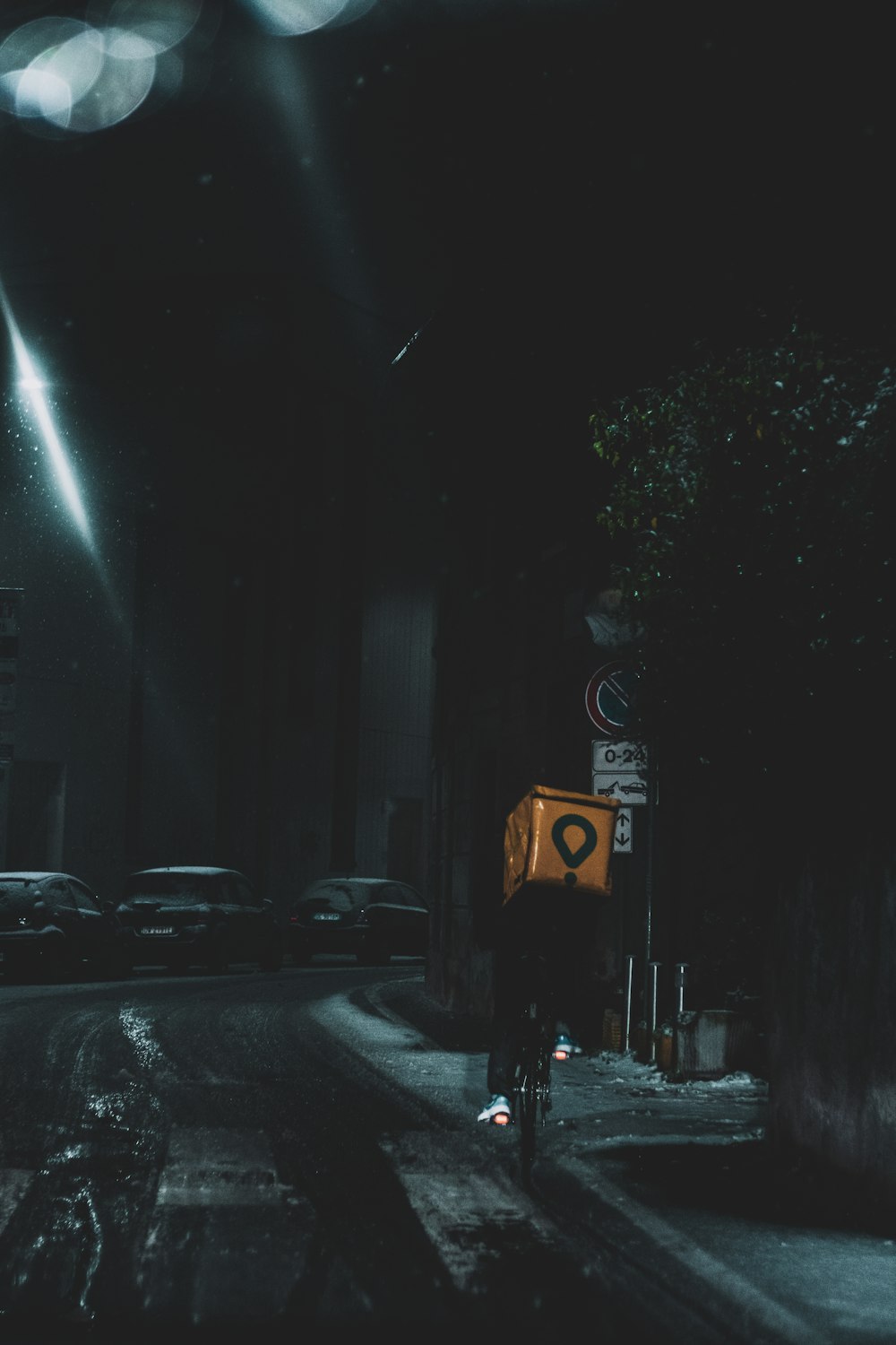 una persona montando en bicicleta por una calle por la noche
