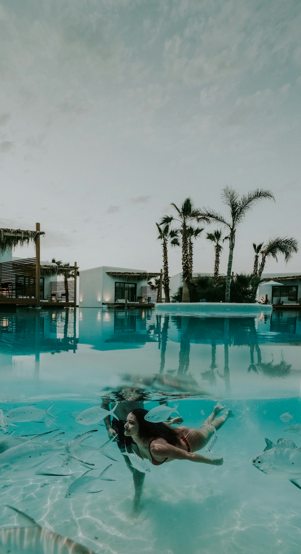 woman swimming on pool under gray sky