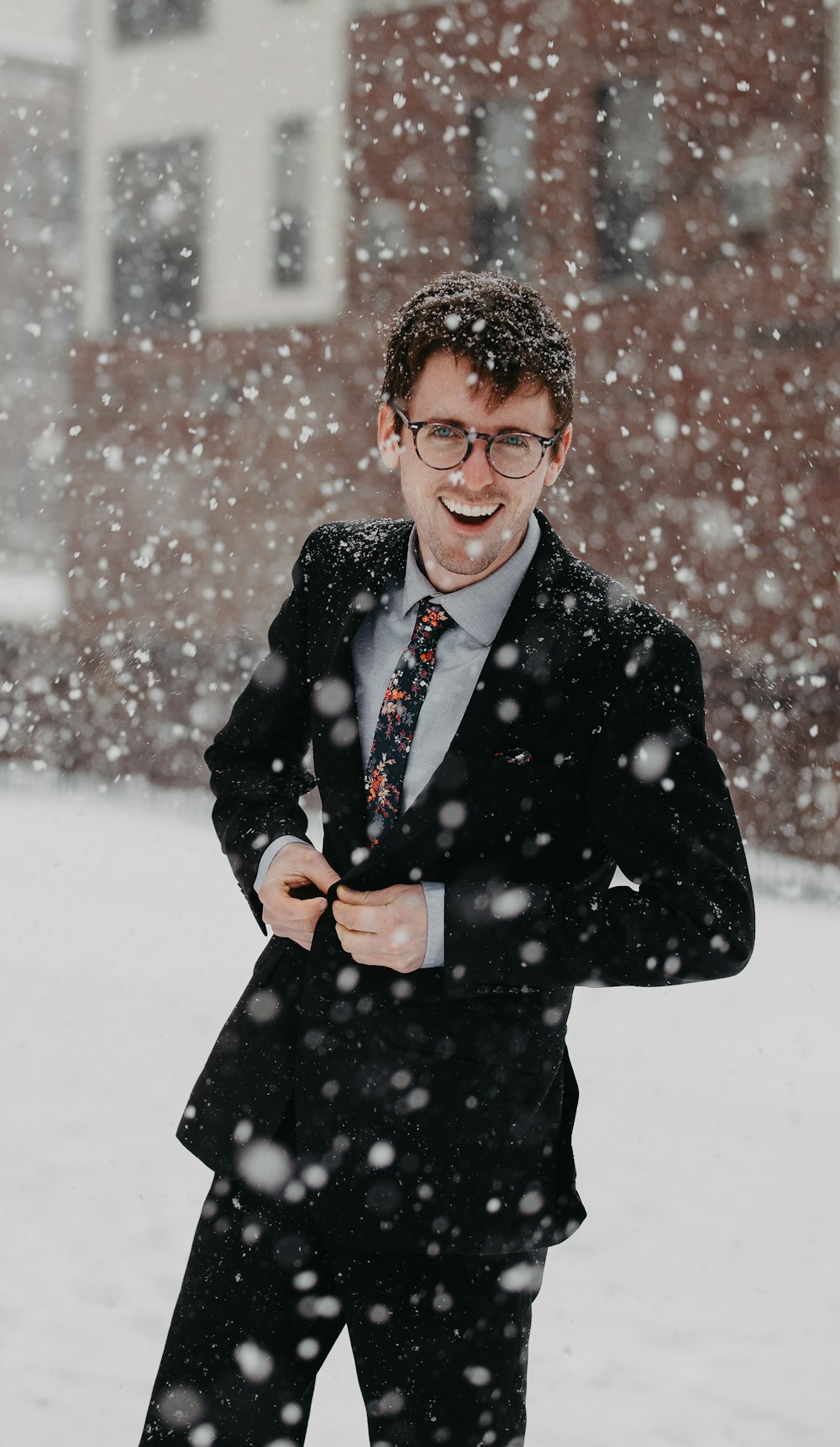 uomo che indossa un vestito nero sotto la neve