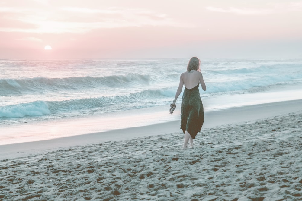 woman walking on shore during daytime