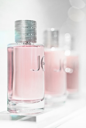 A close-up of three elegant serum bottles with soft natural lighting highlighting their sleek design.