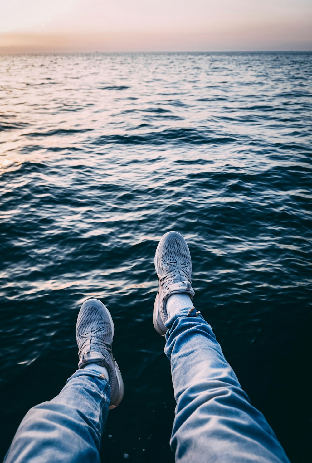 person wearing sneakers near water