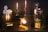 A variety of vintage projectors and mechanical objects are creatively transformed into lamps. The setup features six unique lamps, each with its own style and base, including film reels and gears. The lamps emit a warm, ambient light, casting a cozy glow.