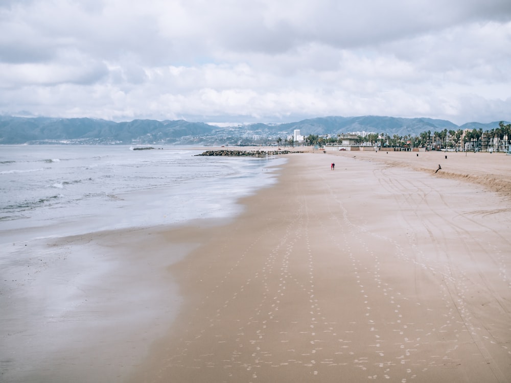 waves crashing shore during daytime