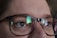Close-up of a person wearing modern eyeglasses in natural light.