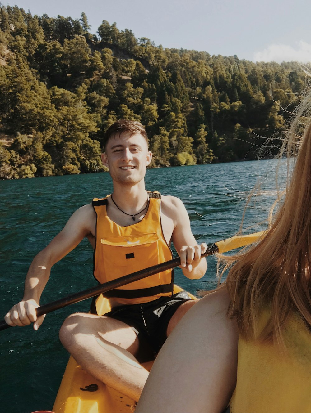 man wearing life vest holding oar during daytime