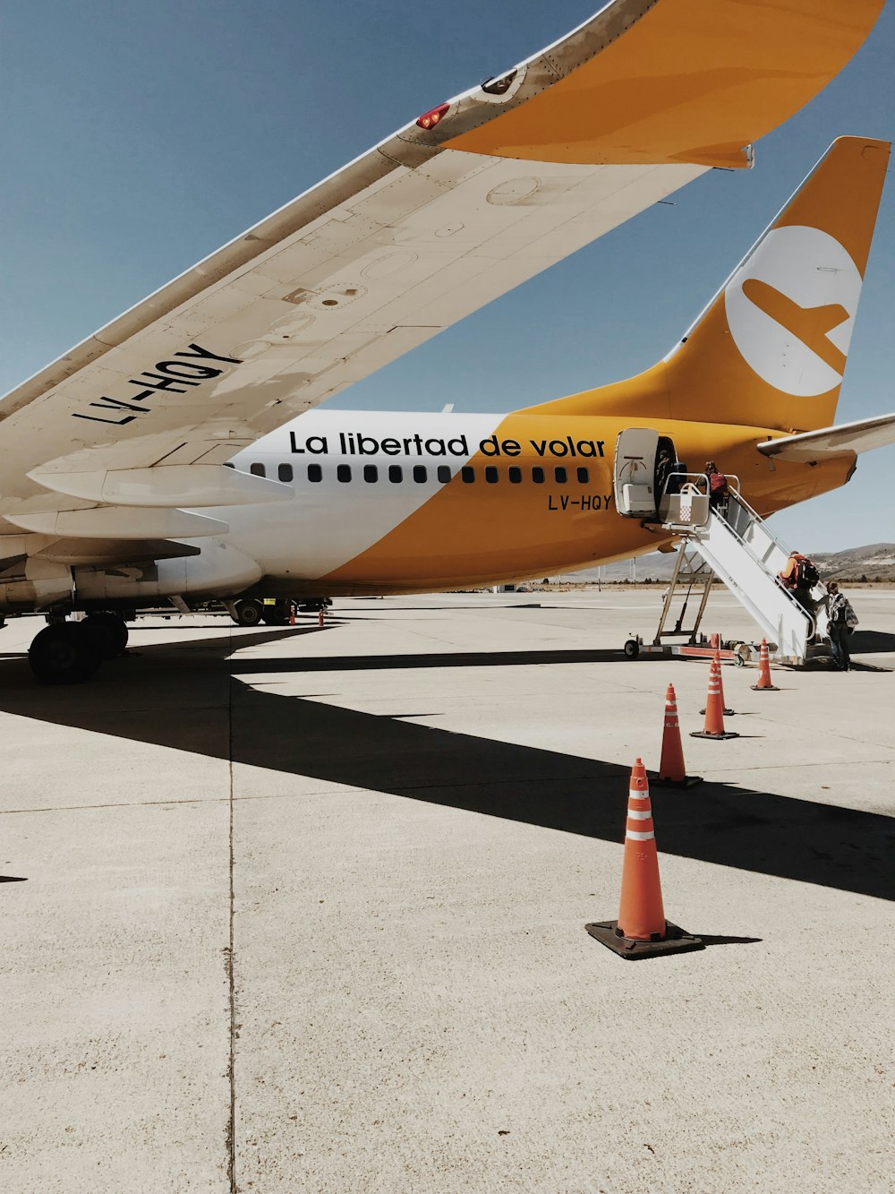 traffic cones beside opened plane at airport during daytime