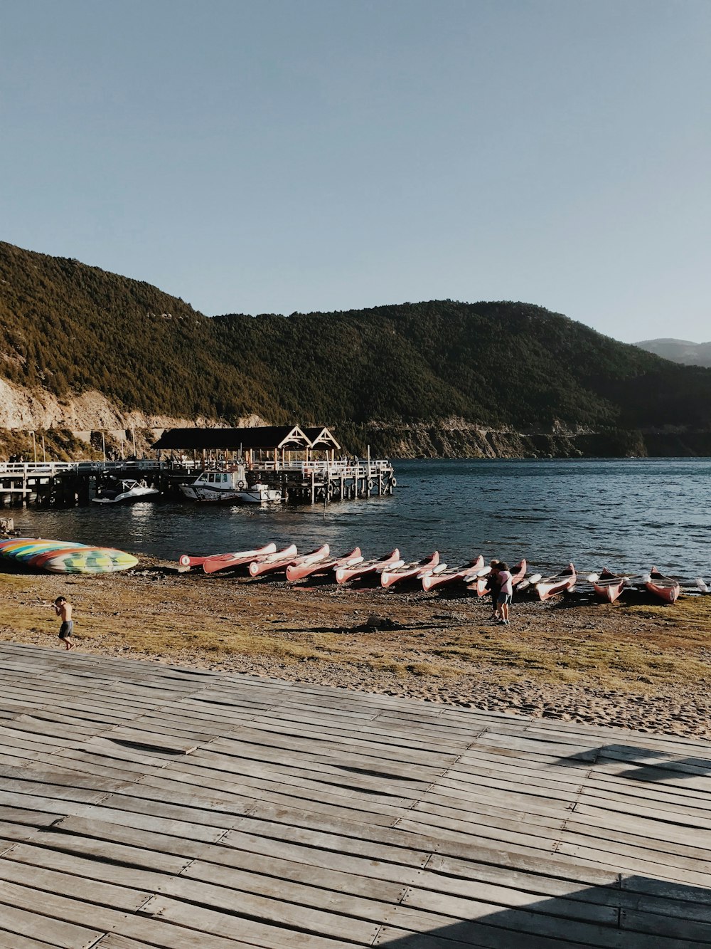 assorted-color canoes beside river near mountains