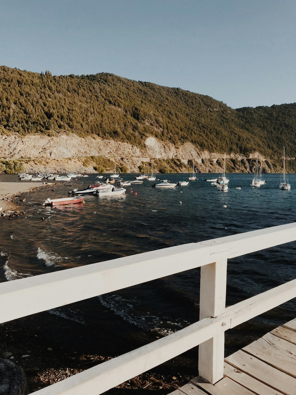 motorboats on body of water near white wooden docks