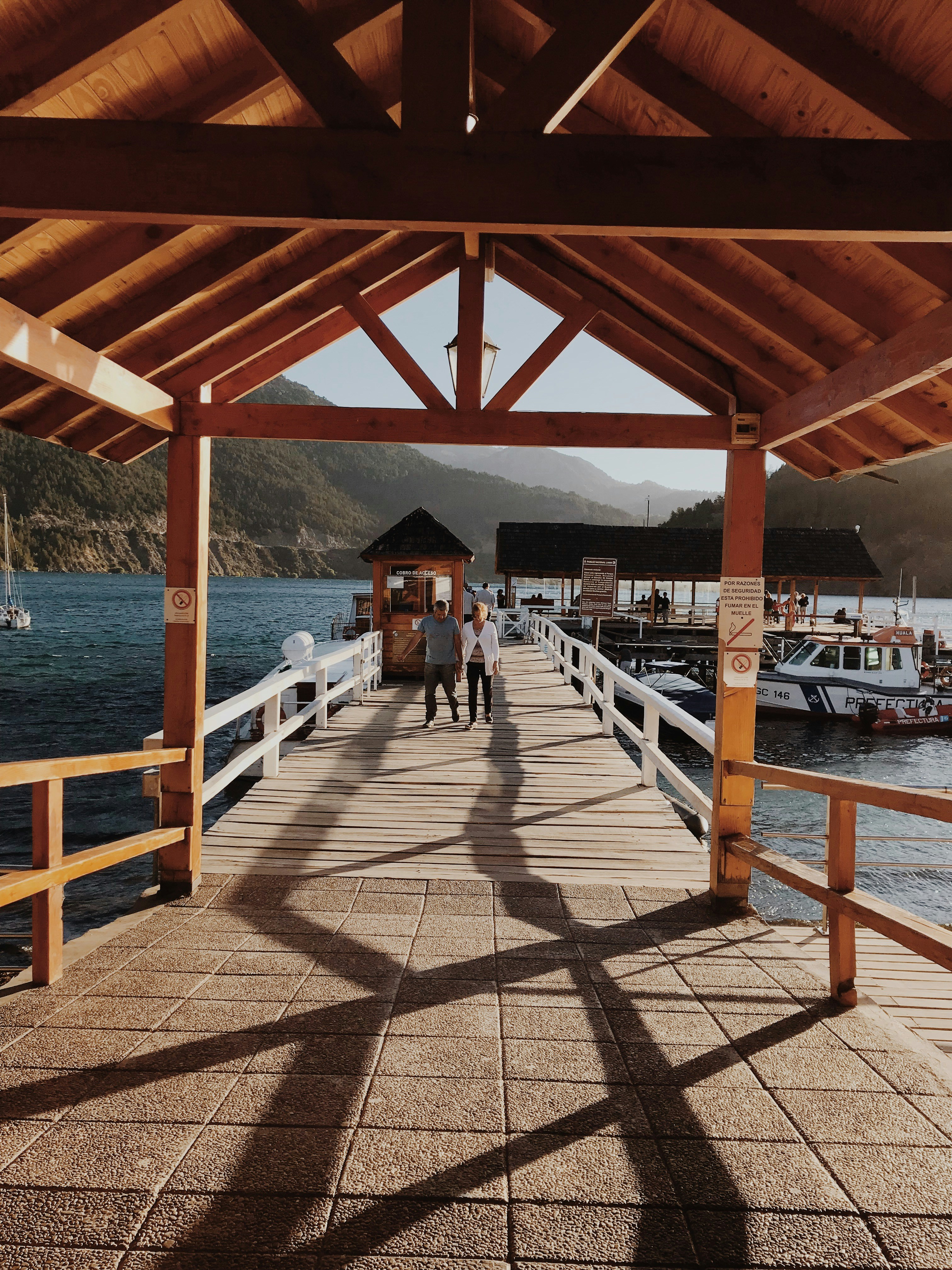 homme et femme marche sur le quai pendant la journée