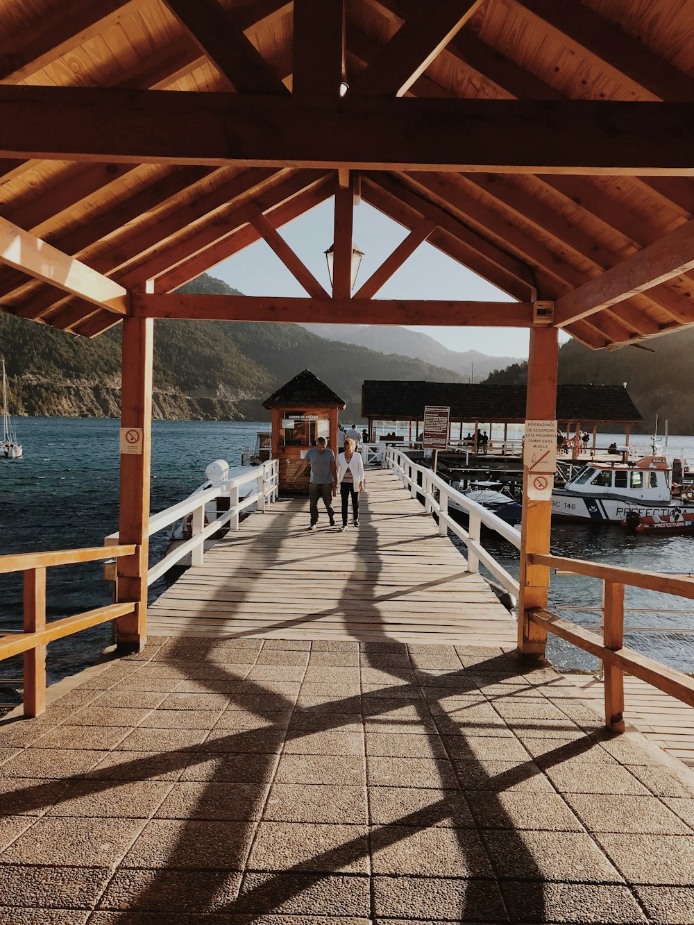 Hombre y mujer camina en el muelle durante el día