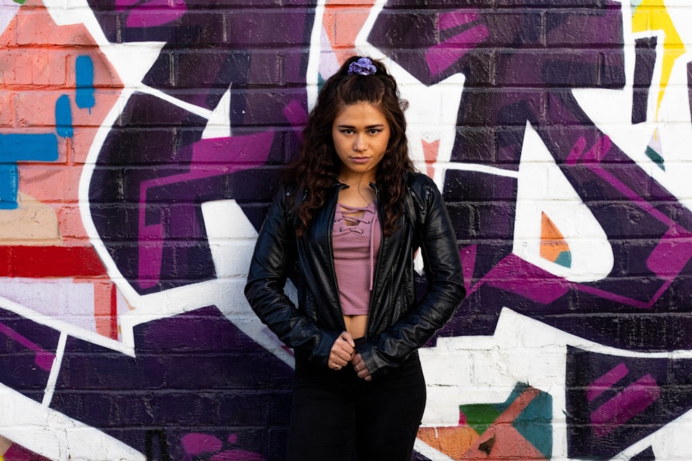 woman standing beside graffiti wall