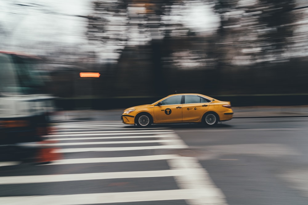 yellow taxi crosses pedestrian lane