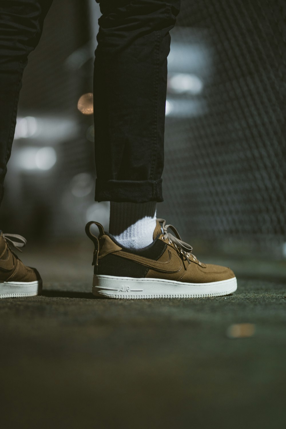 person standing wearing brown and black Nike Air Force 1