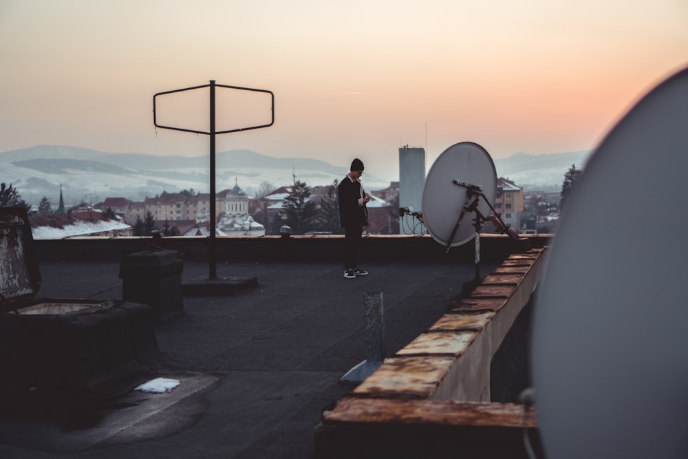 man standing on building rooftop near