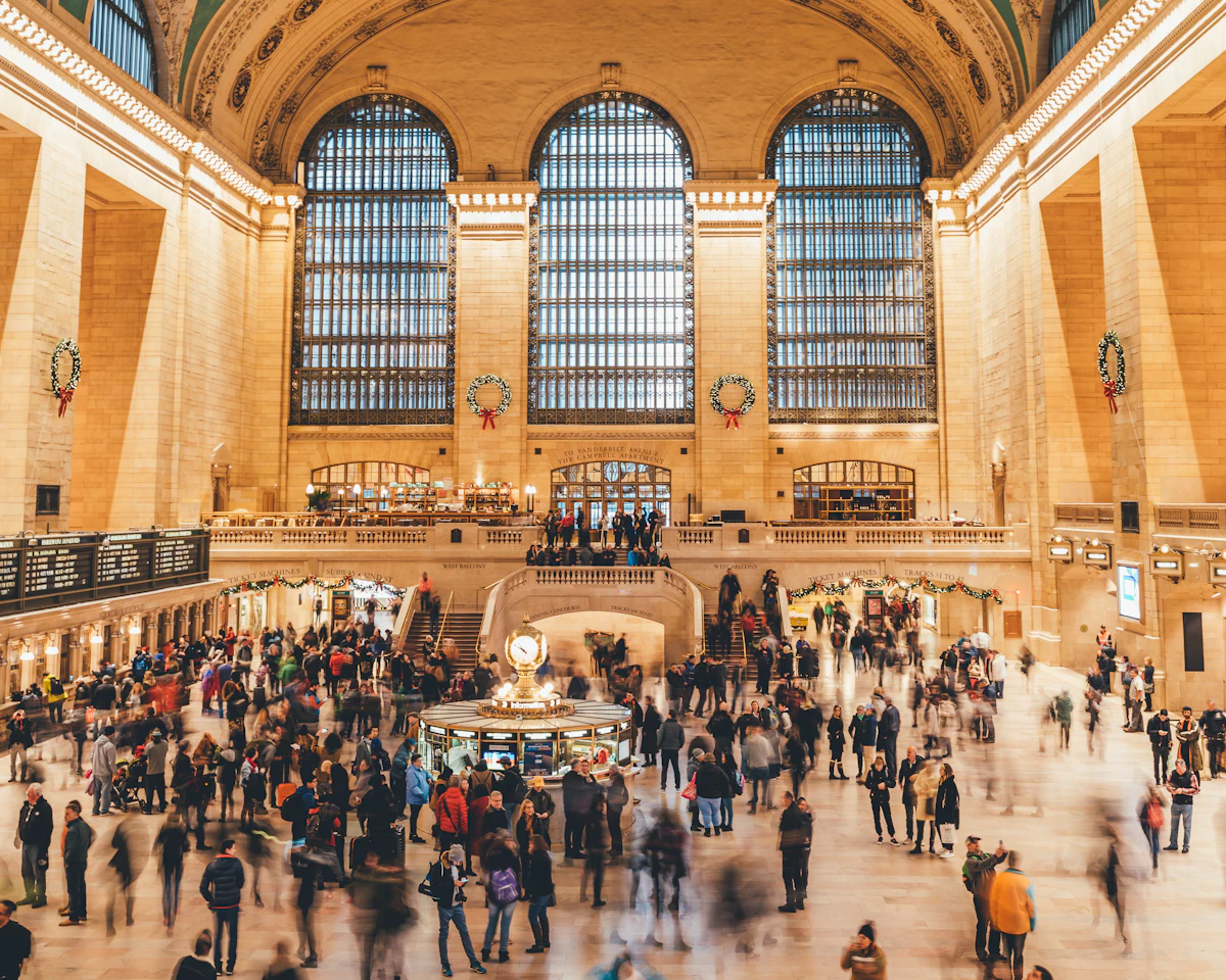 Travelers crowding a busy train station concourse
