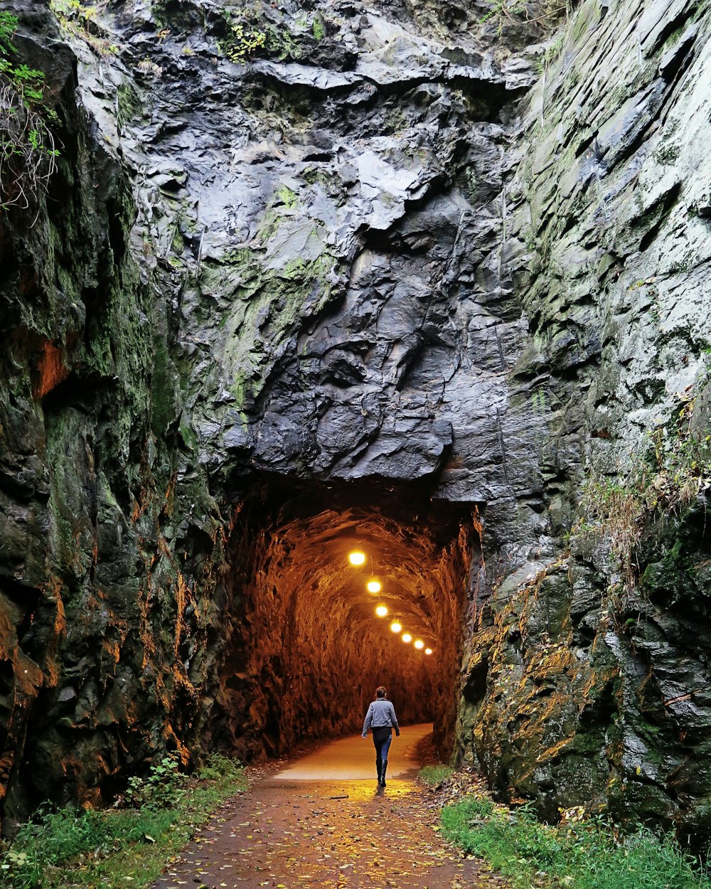 person walking towards tunnel