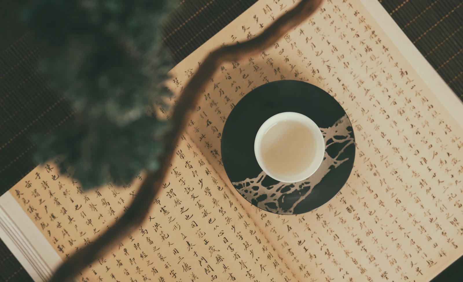 A cup of tea set on calligraphy paper at Tong Chiao